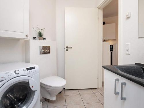 a bathroom with a washing machine and a toilet at 5 person holiday home on a holiday park in Bogense in Bogense