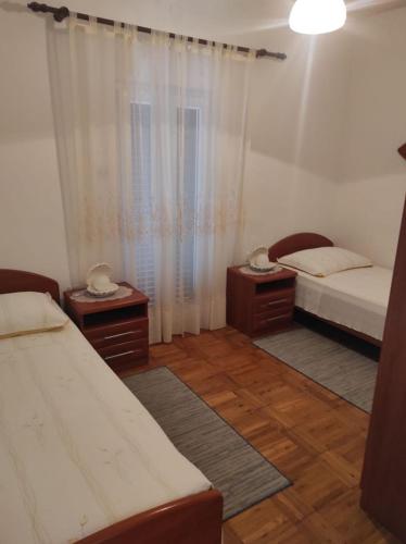 a bedroom with two beds and two night stands at Apartment Tenara in Vis