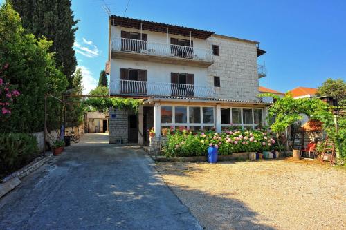 a house with a balcony and flowers in front of it at Apartments Mar in Sutivan