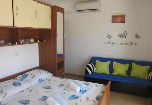 sypialnia z łóżkiem i niebieską kanapą w obiekcie Apartments and Room Dar w Hvarze