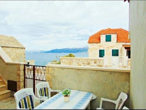 een terras met een tafel en stoelen op een balkon bij Apartment Tonci in Postira