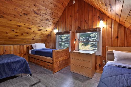 a bedroom with two beds in a wooden cabin at West Park Chalet - Large Vermont Ski Home - Great for Groups! Hot tub, games, ski rental ticket deals! in Killington