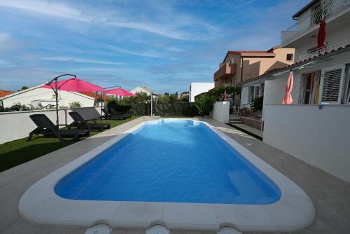 a swimming pool in the backyard of a house at Apartment Mihovilovic in Slatine