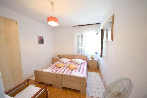a small bedroom with a bed and a window at Rooms Smilje in Orebić