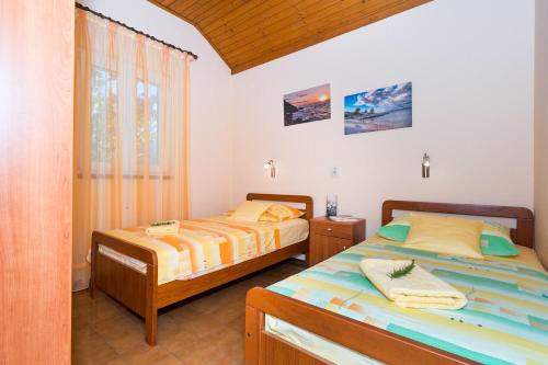 Un dormitorio con dos camas y una ventana en Apartment Mirja, en Nečujam
