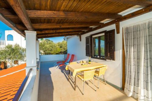 patio con mesa de madera y sillas en el balcón en Apartment Mirja, en Nečujam