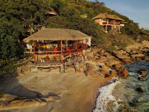 a group of people sitting at a restaurant on the beach at Tao Thong Villa 2 in Ko Tao