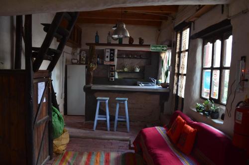 a living room with a kitchen and a bar at Turu Wasi in Tilcara