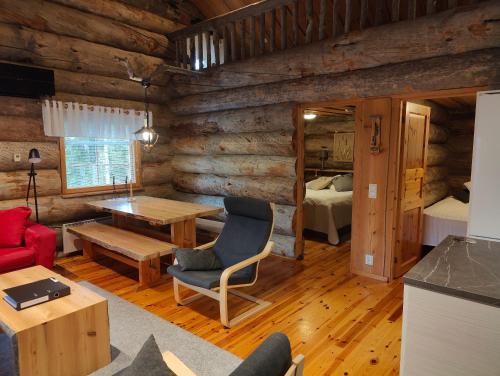 a living room with a desk and a bedroom at Isokelo Log Apartments in Salla