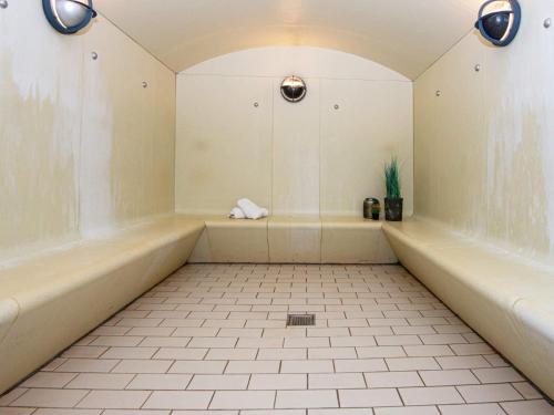 a bathroom with a tub and a tile floor at Apartment with loft in holiday park, Ringkøbing in Ringkøbing