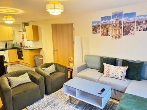 a living room with a couch and two chairs and a table at The Vogue Stay, 3 Bedrooms, 2 bathrooms, Ideal for JR & Oxford Hospitals, FREE CarPark, Conveniently located for Ring Road access, 2 miles from Oxford City Centre easy car & bus route in Oxford