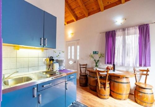 a kitchen with a table and some wooden barrels at Apartments Zeljko in Račišće
