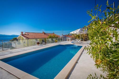 a swimming pool in the backyard of a house at Apartments Saga in Lokva Rogoznica