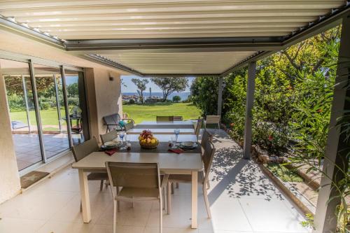 une salle à manger avec une table et des chaises sur un patio dans l'établissement A Cala d Oro et plage privée pour 8, à Porto-Vecchio