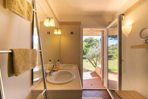 a bathroom with a sink and a mirror at A Cala d Oro et plage privée pour 8 in Porto-Vecchio