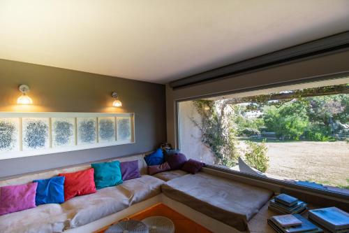 a living room with a couch and a large window at A Cala d Oro et plage privée pour 8 in Porto-Vecchio