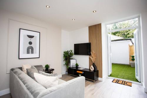 a living room with a couch and a tv at The Cove - Roker Sea Front - Vacant Nests in Monkwearmouth