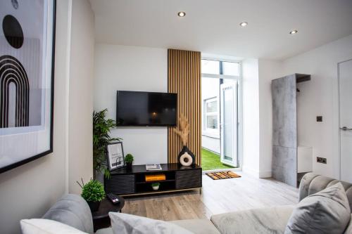 a living room with a couch and a flat screen tv at The Cove - Roker Sea Front - Vacant Nests in Monkwearmouth