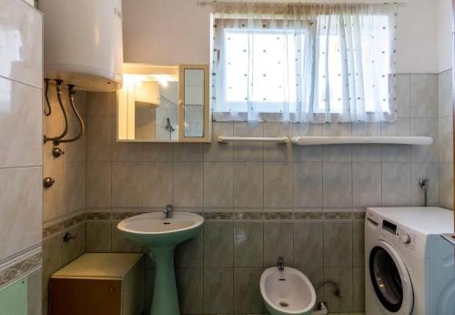 łazienka z umywalką i pralką w obiekcie Apartment Nadica w Fažanie