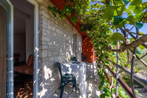 a table and chairs on the porch of a house at Apartments Perci in Krnica