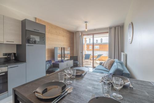 une cuisine avec une table avec des verres à vin dessus dans l'établissement Alpe d'Huez Houses - Chez Stef - Alpe d'Huez Houses - 45m2 de confort plein sud, à L'Alpe-d'Huez