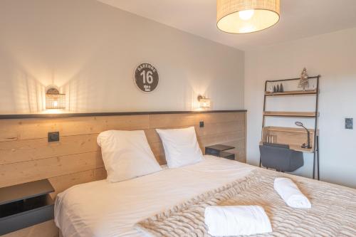 ein Schlafzimmer mit einem Bett mit zwei Handtüchern darauf in der Unterkunft Alpe d'Huez Houses - Chez Stef - Alpe d'Huez Houses - 45m2 de confort plein sud in L'Alpe-d'Huez