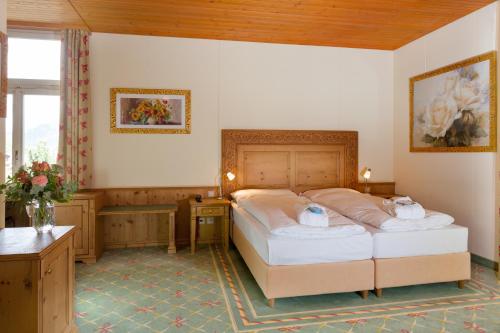 a bedroom with a bed with two towels on it at Sporthotel Wildstrubel in Lenk