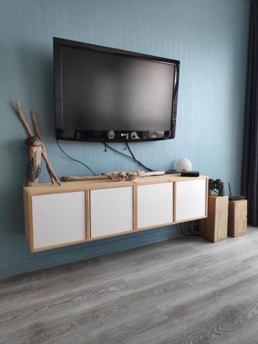 - une télévision à écran plat installée au-dessus d'un centre de divertissement dans l'établissement Duplex 4 personnes - Face mer, à Bray-Dunes