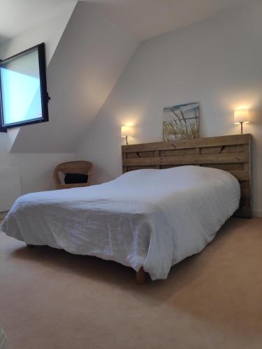 - une chambre avec un lit doté d'une couette blanche et d'une fenêtre dans l'établissement Duplex 4 personnes - Face mer, à Bray-Dunes