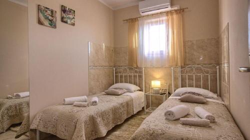 une chambre avec deux lits et une fenêtre dans l'établissement House Kova, à Ližnjan