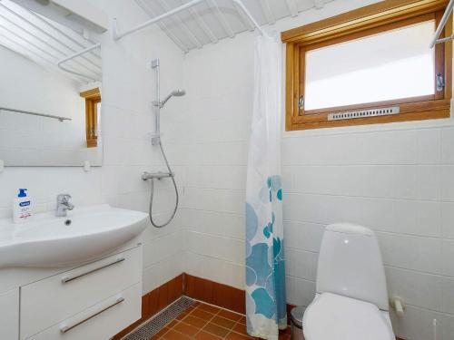 Un baño con lavabo, inodoro y ventana. en 6 person holiday home in Gilleleje, en Gilleleje