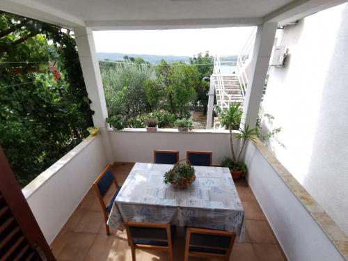 a small balcony with a table and chairs on a balcony at Apartment Goran in Nečujam