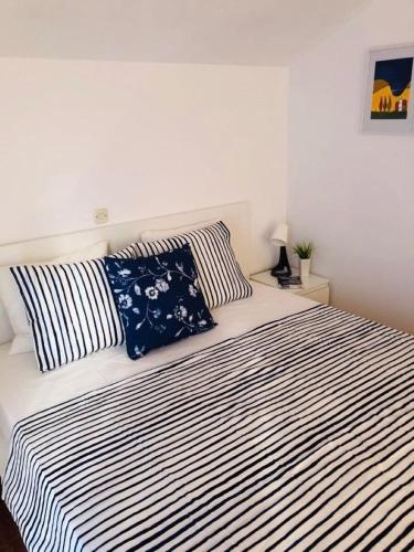 a bedroom with a black and white bed with two pillows at Apartment Linda1 in Lumbarda