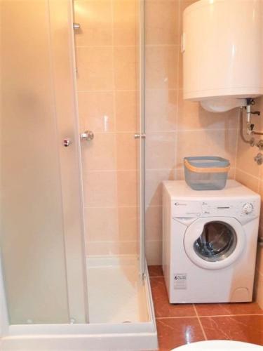 a bathroom with a washing machine and a washer at Apartment Linda1 in Lumbarda