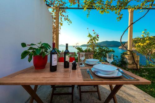 a wooden table with wine bottles and plates on it at Apartments Diana in Dubrovnik