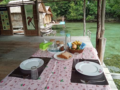 a picnic table with plates and a basket of food at Pin Wawiyai Natural Homestay in Yennanas Besir