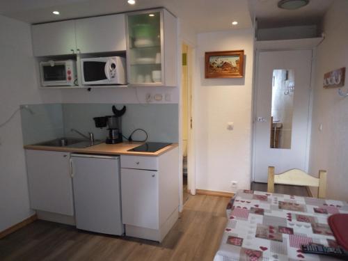 une petite cuisine avec un évier et un micro-ondes dans l'établissement Studio cosy pour 2 · Balcon · Proche pistes et commerces · Animaux admis - FR-1-181-2234, à La Plagne Tarentaise