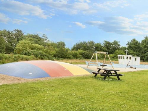 a park with a playground and a table and a swing at Grand holiday home- Type 11 in Blåvand
