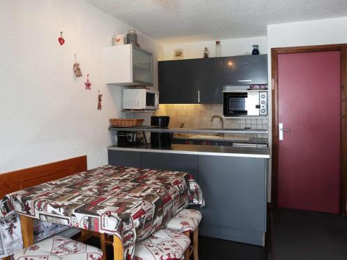 - une petite cuisine avec une table et un comptoir dans l'établissement Studio 4 pers au pied des pistes avec balcon - FR-1-322-550, aux Orres