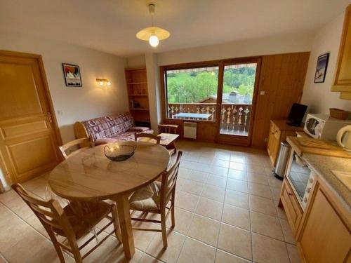 une cuisine et un salon avec une table et un canapé dans l'établissement Bel appartement 4 pers. avec balcon et garage au Grand-Bornand - FR-1-458-189, au Grand-Bornand