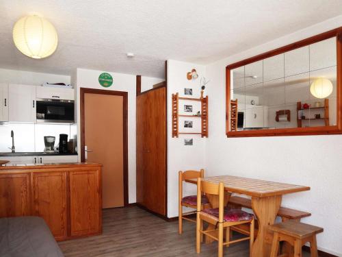 une cuisine et une salle à manger avec une table et des chaises dans l'établissement Studio au cœur des Orres 1650, accès pistes, balcon - FR-1-322-574, aux Orres