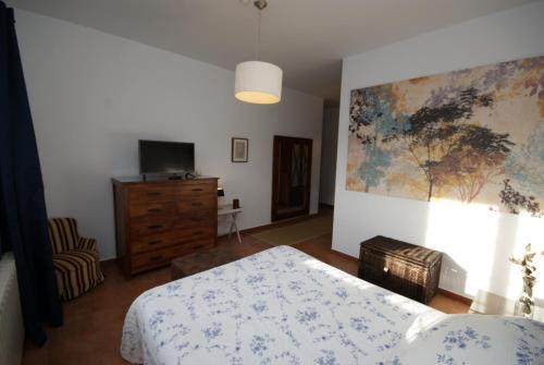a bedroom with a bed and a painting on the wall at Finca El Romeral in Alpera