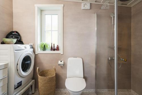 a bathroom with a washing machine and a toilet at Guestly Homes - Charming 3BR House, 2 Full Baths Near City in Piteå