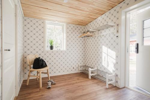 a room with a chair and a wooden ceiling at Guestly Homes - Charming 3BR House, 2 Full Baths Near City in Piteå
