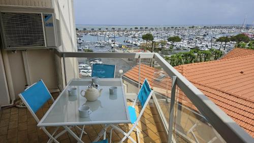 un balcon avec une table et des chaises et une vue sur un port dans l'établissement Vaste appartement avec vue sur le port de plaisance, à Arcachon