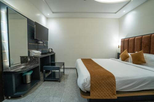 a hotel room with a bed and a mirror at Hotel The Vaishvik in Katra