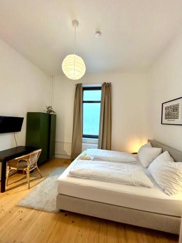 a bedroom with a bed and a desk and a window at FeWo Lessingstube nahe Jägermeister in Wolfenbüttel