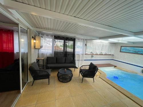 a living room with a pool and a couch and chairs at Pool & Chill in Pierrefitte-sur-Seine