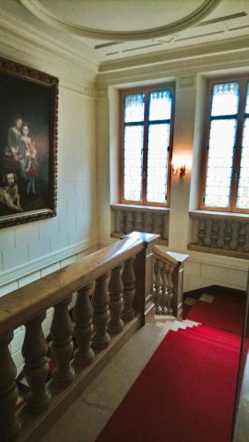 a large room with a painting on the wall and a staircase at Chambres d'hôtes au Château Léon in Morvillars