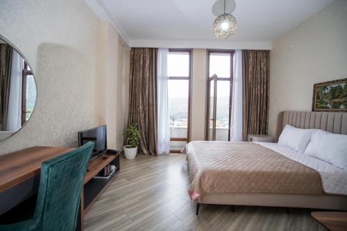 a bedroom with a bed and a desk and a mirror at North Hotel in Qusar